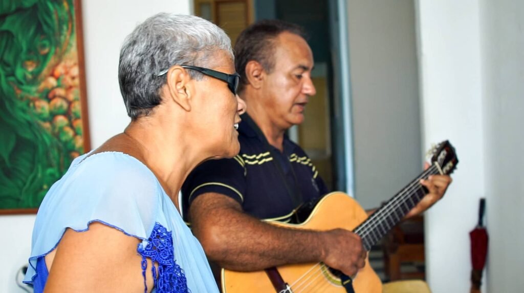 dos personas, una cantando y la otra con guitarra