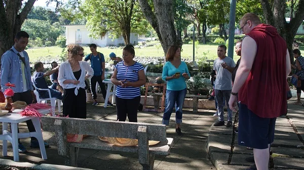 Grupo de personas de diversas edades en un espacio al aire libre con árboles